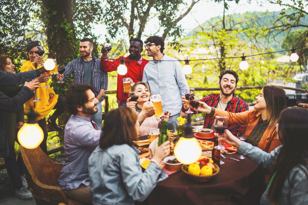 A quiet day with friends toasting together with wine and beer at sunset time, Garden, Italy | SUPERPOBYT Travel